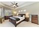 Comfortable main bedroom with elegant tray ceiling, a cozy seating area, and dresser at 8103 Snowy Egret Pl, Bradenton, FL 34202