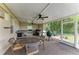Covered outdoor kitchen area with stainless grill, bar seating, and a ceiling fan at 8103 Snowy Egret Pl, Bradenton, FL 34202
