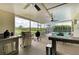 Outdoor kitchen with stainless steel appliances in a covered area that leads to a pool at 8103 Snowy Egret Pl, Bradenton, FL 34202