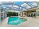Inviting screened pool area with lounge chairs, view of manicured lawn, and outdoor furniture at 8103 Snowy Egret Pl, Bradenton, FL 34202