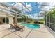 Screened pool with clear blue water, outdoor seating, and view of surrounding greenery at 8103 Snowy Egret Pl, Bradenton, FL 34202