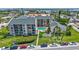 Aerial view of condo complex featuring a pool, landscaping, ample parking, and a waterfront view at 845 Benjamin Franklin Dr # 302, Sarasota, FL 34236