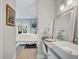 Modern bathroom with vanity, decorative mirror, and entrance to a bedroom with outdoor access at 845 Benjamin Franklin Dr # 302, Sarasota, FL 34236