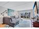 Cozy living room featuring a comfortable gray sectional, stylish rug, modern art, and plenty of natural light at 845 Benjamin Franklin Dr # 302, Sarasota, FL 34236