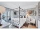 Serene main bedroom with a four-poster bed, balcony access, and stylish furnishings at 845 Benjamin Franklin Dr # 302, Sarasota, FL 34236