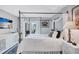Bright bedroom with a canopy bed, balcony, white linens, and tasteful decor at 845 Benjamin Franklin Dr # 302, Sarasota, FL 34236