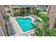 Community pool area with lounge chairs, tables, and lush tropical landscaping at 845 Benjamin Franklin Dr # 302, Sarasota, FL 34236