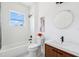 Bathroom with shower/tub combo, wood vanity, and round mirror at 8622 Inwood Dr, Hudson, FL 34667