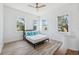 Bright bedroom with three windows, ceiling fan, and wood-look flooring at 8622 Inwood Dr, Hudson, FL 34667