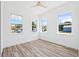 Bright bedroom with three windows and wood-look flooring at 8622 Inwood Dr, Hudson, FL 34667