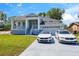 Beautiful home featuring a lush lawn, a covered front porch and a driveway with two stylish vehicles parked out front at 8622 Inwood Dr, Hudson, FL 34667