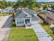 Aerial view of a charming home, landscaped yard, concrete driveway, and a gray shingle roof at 8622 Inwood Dr, Hudson, FL 34667