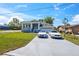 Charming home featuring a manicured lawn and a driveway with two stylish vehicles parked out front at 8622 Inwood Dr, Hudson, FL 34667