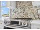 Close up of stainless steel range with quartz counters and stone backsplash at 8622 Inwood Dr, Hudson, FL 34667