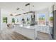 Bright, modern kitchen featuring a large island, stainless appliances, stone backsplash, and a dining area at 8622 Inwood Dr, Hudson, FL 34667