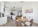 Modern kitchen and dining area with sleek, white cabinetry, stainless appliances, and stylish, light-colored floors at 8622 Inwood Dr, Hudson, FL 34667