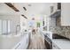 Bright kitchen with stainless steel appliances, white cabinetry, quartz countertops and eat-in dining area at 8622 Inwood Dr, Hudson, FL 34667