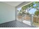 View of the porch featuring white railings, gray wood flooring, and walls of light blue wood paneling at 8622 Inwood Dr, Hudson, FL 34667