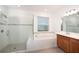 Bathroom featuring separate shower, soaking tub, wood cabinet vanity, and neutral tiling at 10171 Milky Way Cir, Sarasota, FL 34241