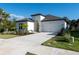 This new build home boasts a modern exterior with neat landscaping, a lawn, and a paved driveway at 10171 Milky Way Cir, Sarasota, FL 34241