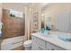 Bathroom with tiled shower, white cabinets, and a coordinated color scheme at 11508 Griffith Park Ter, Bradenton, FL 34211