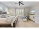 Comfortable bedroom featuring a bed, dresser with a TV, a cozy chair, and natural light with plantation shutters at 11508 Griffith Park Ter, Bradenton, FL 34211