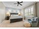 Inviting bedroom with a dark wood bed frame, a cozy armchair, and ample natural light from shuttered windows at 11508 Griffith Park Ter, Bradenton, FL 34211
