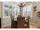 Cozy breakfast nook with plantation shutters, chandelier, and woven chairs surrounding a wooden table, bathed in natural light at 11508 Griffith Park Ter, Bradenton, FL 34211
