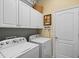 Bright laundry area featuring front loading washer/dryer and upper cabinets at 11508 Griffith Park Ter, Bradenton, FL 34211
