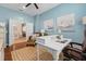 Inviting home office with blue walls, white desk, and a comfortable chair, complemented by natural light and calming decor at 11508 Griffith Park Ter, Bradenton, FL 34211