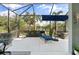 Screened patio with sunbathing lounger, dining set, and lush backyard views at 11508 Griffith Park Ter, Bradenton, FL 34211