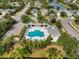 Aerial view of a community pool with spa, seating, umbrella and lush landscaping at 11508 Griffith Park Ter, Bradenton, FL 34211