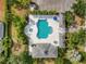 Aerial view of a community pool with lounge chairs, umbrella, spa, and ample parking at 11508 Griffith Park Ter, Bradenton, FL 34211