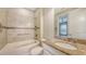 Bright bathroom featuring a tiled bathtub, granite countertop vanity, and a view to the primary bedroom at 12619 Sorrento Way, Bradenton, FL 34211