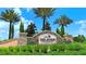 Esplanade Golf & Country Club entrance sign framed by lush greenery and palm trees under a bright blue sky at 12619 Sorrento Way, Bradenton, FL 34211