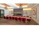 Interior view of a formal dining room with a long table, red chairs, and modern lighting at 12619 Sorrento Way, Bradenton, FL 34211