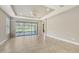 Spacious living room featuring tiled floors, a tray ceiling with a fan, and sliding glass doors to the patio at 12619 Sorrento Way, Bradenton, FL 34211
