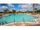 Community pool with baja steps and a variety of seating at 12619 Sorrento Way, Bradenton, FL 34211
