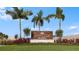 Entrance sign featuring lush landscaping and palm trees welcomes you to the Vinterra Townhomes community at 15172 Cuzcorro Ct, Nokomis, FL 34275