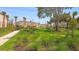 Lush community green space featuring manicured lawns, walking path, and native plantings at 15172 Cuzcorro Ct, Nokomis, FL 34275