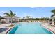 Beautiful community pool featuring a covered lounge area with tables and chairs at 15172 Cuzcorro Ct, Nokomis, FL 34275