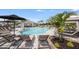 Resort-style pool and lounging area with ample seating and umbrellas for relaxation at 15172 Cuzcorro Ct, Nokomis, FL 34275