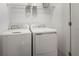 Functional laundry room with standard-size washer and dryer, and overhead shelving at 15196 Cuzcorro Ct, Nokomis, FL 34275
