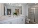 Modern bathroom with double vanity, quartz countertops and glass-enclosed shower at 15200 Cuzcorro Ct, Nokomis, FL 34275