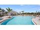 Community pool with a covered patio, lounge chairs, and lush landscaping, perfect for relaxing outdoors at 15200 Cuzcorro Ct, Nokomis, FL 34275