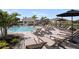 Community pool area with many lounge chairs and a covered patio area overlooking the pool at 15200 Cuzcorro Ct, Nokomis, FL 34275