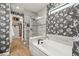 Elegant bathroom featuring a soaking tub, frameless glass shower, and a walk-in closet with custom shelving at 16226 Hidden Oak Loop, Lakewood Ranch, FL 34211