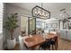Stylish dining room with a wooden table, modern light fixture, and an open view into the cozy living room at 16226 Hidden Oak Loop, Bradenton, FL 34211