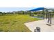 A grassy dog park featuring shaded benches and water access, offering a comfortable space for dogs and their owners at 16226 Hidden Oak Loop, Lakewood Ranch, FL 34211