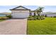 Charming single-Gathering home featuring a well-manicured lawn, paver driveway, and an attached two-car garage at 16226 Hidden Oak Loop, Lakewood Ranch, FL 34211